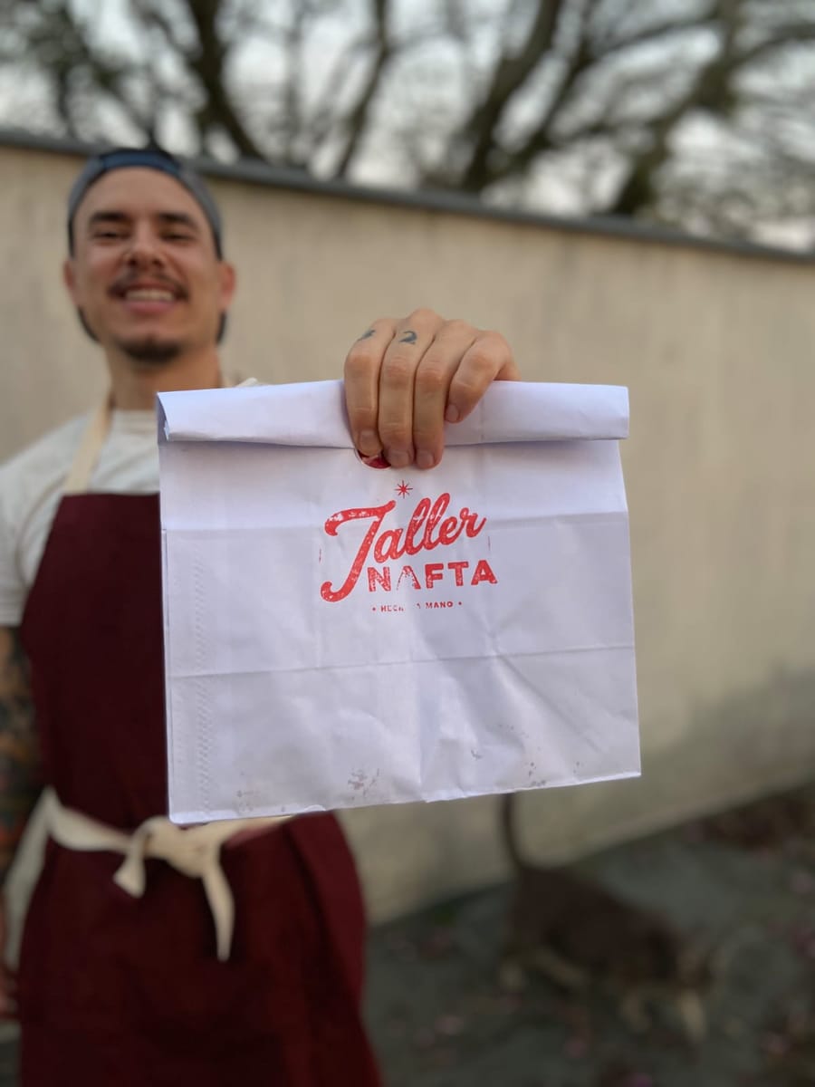 Padeiro Leo Zacki segurando a embalagem artesanal da Taller Nafta